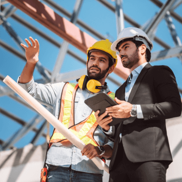 Two men discussing a construction project at a job site