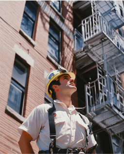 A man lookin upwards standing at the construction site