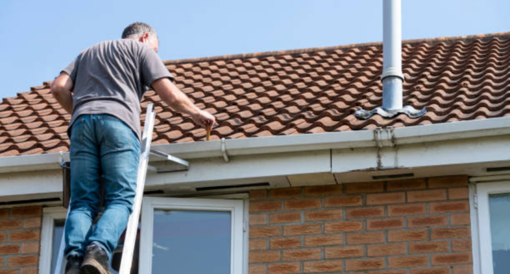 Roof leak repair in progress, contractor fixing shingles and sealing cracks for waterproofing and damage prevention.