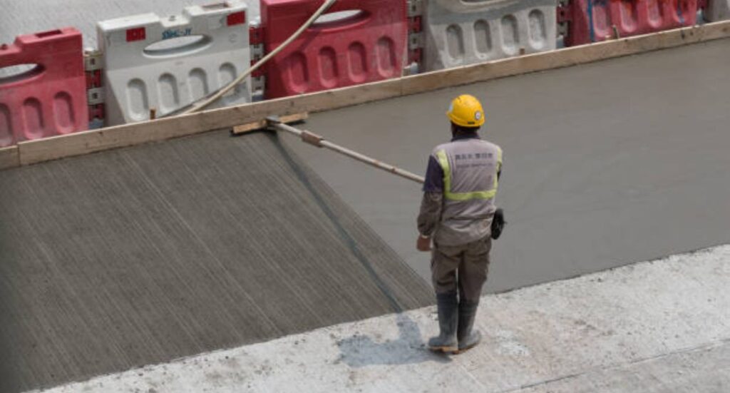 Worker applying Thoroseal waterproofing coating on concrete surface using long-handle roller for smooth, durable finish